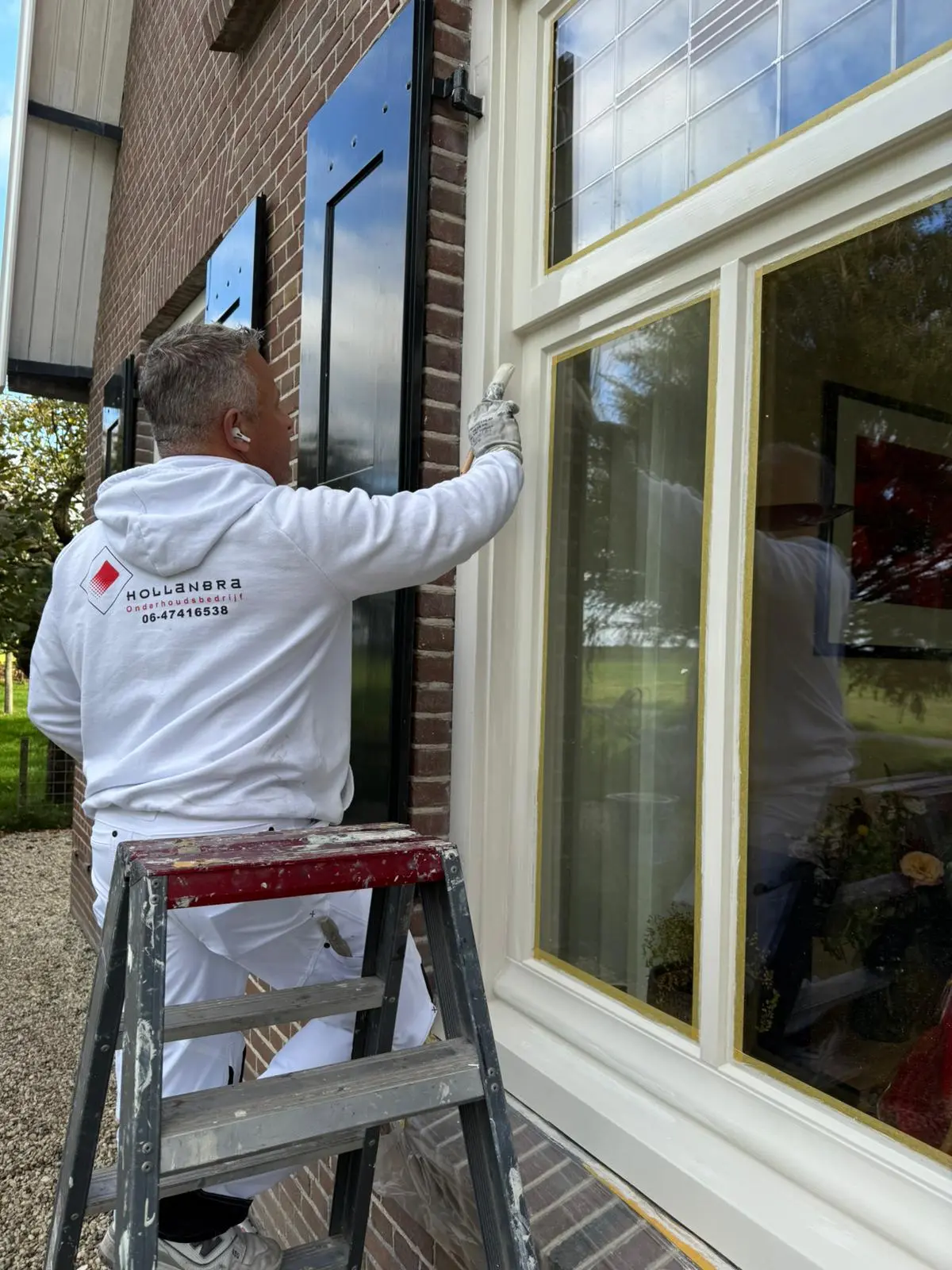Buitenschilderwerk: kozijn wordt met de kwast afgewerkt