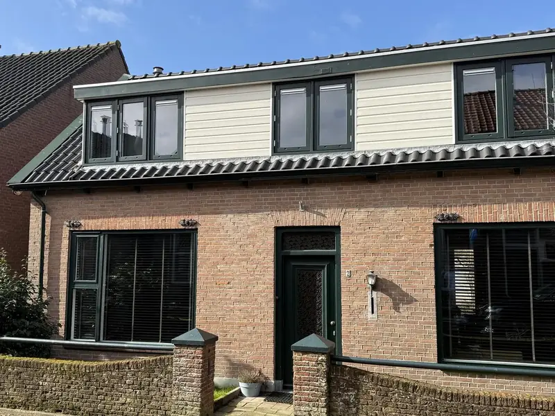 Woning met dakkapel, lichte betimmering en groene kozijnen