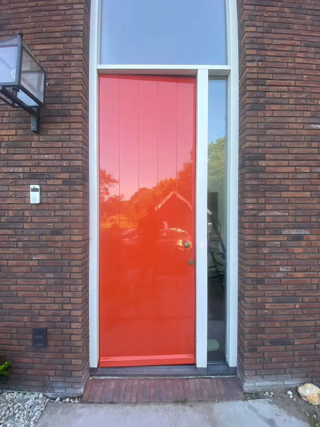 Voordeur in helder rood na schilderwerk, met wit kozijn